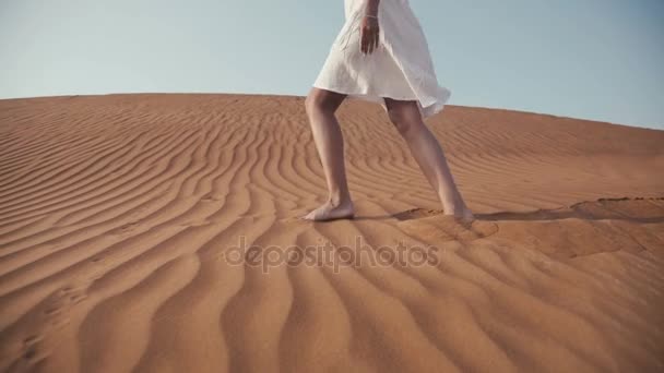 Mince fille dans une robe blanche va pieds nus sur le sable dans le désert — Video