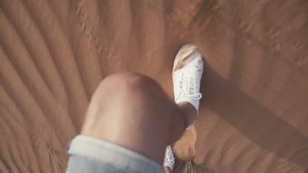 Vista desde arriba: un hombre en zapatillas blancas camina por el desierto — Vídeos de Stock