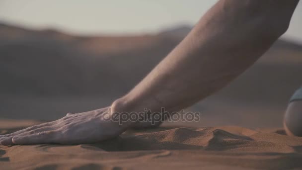 男性の手のクローズ アップは、砂漠の砂の一握りを取る. — ストック動画
