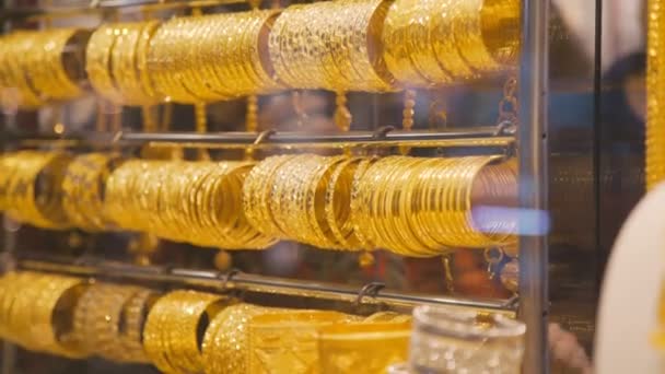 Escaparate con pulseras de oro. Tienda de joyas. Pulseras de oro en venta . — Vídeos de Stock