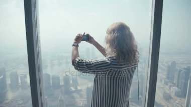 Pencerenin önünde duran ve bir cep telefonu fotoğraflandı kız turizm