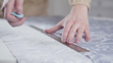 Bir terzi el yakın çekim. Kesme hattı üzerinde kumaş kaplı