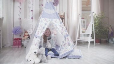 DIY çadırda yumuşak oyuncaklar ile sarışın saçlı küçük şirin kız