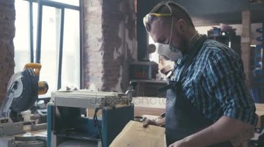 Tezgah üzerinde elinde keski ile marangoz.