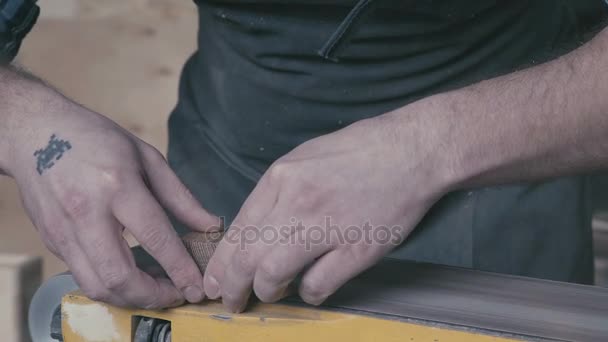 Tischler hält das Holz und poliert es. Details der Arbeit — Stockvideo