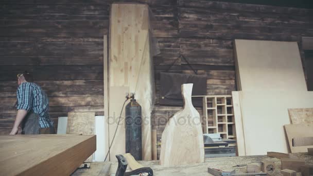 Moderno carpintero sosteniendo un hacha y cortando un trozo de madera . — Vídeos de Stock