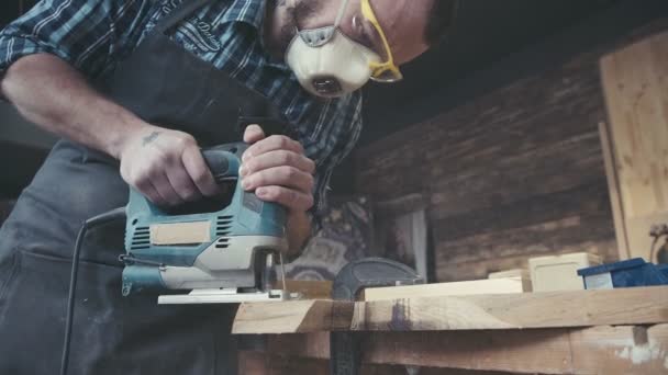 Joiner fungerar med en elektrisk sticksåg och bearbetar trä produkter — Stockvideo