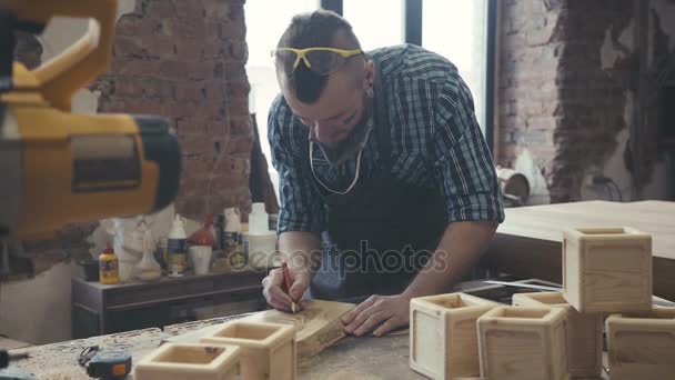 Ξυλουργός συνεργάζεται με ένα ηλεκτρικό παζλ και επεξεργάζεται ξύλινα προϊόντα — Αρχείο Βίντεο