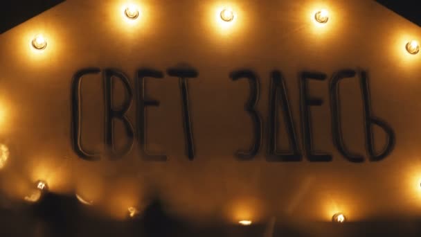 Signe rétro, décoré avec des lumières électriques. Inscription La lumière ici 