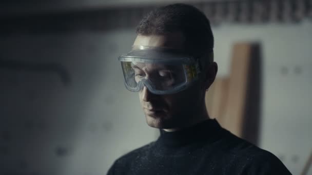 Ambachtsman met opgeslagen glazen op werkstation. Man in een beschermend masker — Stockvideo