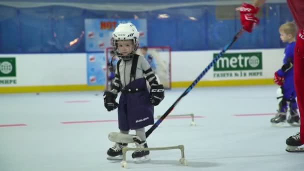 Россия, Новосибирск, 2017: Тренер на льду с маленьким хоккеем — стоковое видео
