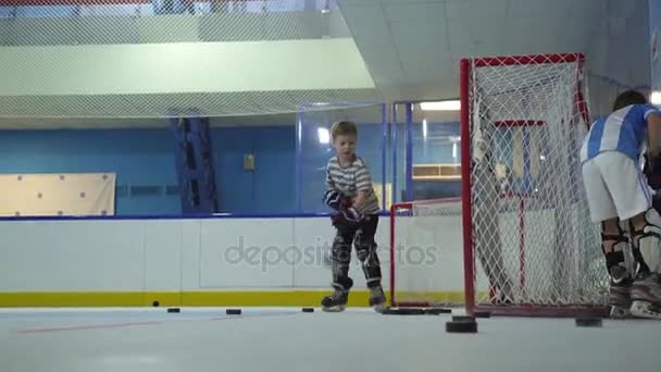Oroszország, Novoszibirszk, 2017: Fiú megtanulni játszani a jégkorong, a cél — Stock videók