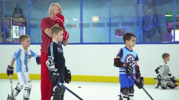 Ryssland, Novosibirsk, 2017: han coach på isen ger juniorer träning. — Stockvideo