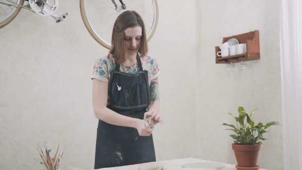 Jong meisje heeft een keramist klei Brok in handen en kneedt de klei — Stockvideo