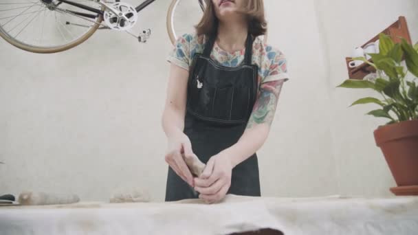Giovane donna in un grembiule elegante è impegnata in un elegante studio di ceramica — Video Stock