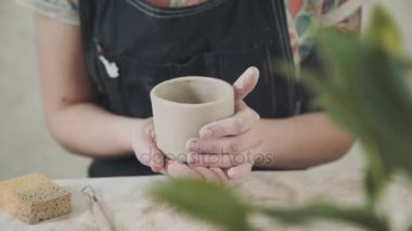 Potter kil ürün ile kadının el. Gonchar düzgünleştirir formu Stein.