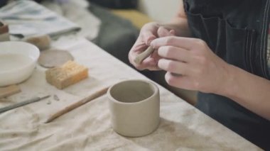 Erkek Close-Up ustası eller. Kadın potter kil kupa yapmak