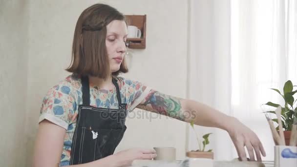 Kvinna keramiker i eleganta studio att dreja, sitter vid bordet — Stockvideo