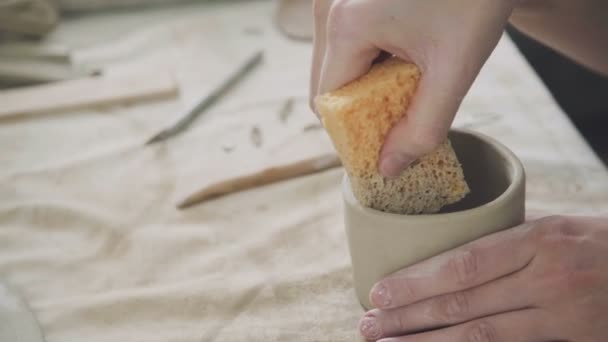 Prodotti ceramici fatti a mano: il padrone con una spugna umida liscia — Video Stock