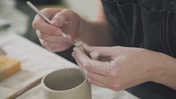 Hands of the potter: a woman potter uses special tools and makes stein — Stock Video