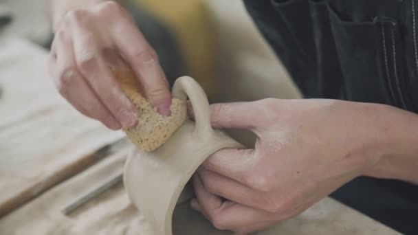 Händerna på potter: kvinna keramiker dub tom stein med svamp — Stockvideo