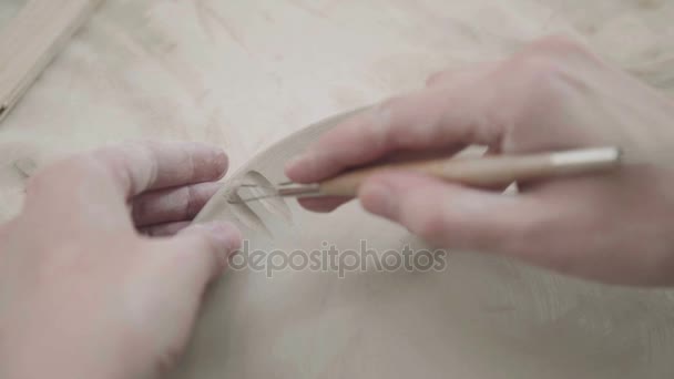 Ceramista hace plato de arcilla y decorar con la ayuda de la pila . — Vídeo de stock