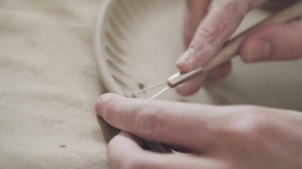 Céramiste des mains : dessin d'un motif sur une plaque d'argile. Céramiste fait plaque — Video