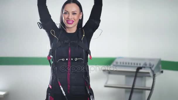 Fitness dívka v obleku elektrická svalová stimulace dělat cvičení EMS — Stock video