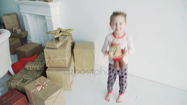 A cute little girl is playing around with gift boxes. Festive day — Stock Video