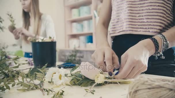 Ανθοκόμος κάνει γαμήλια ανθοδέσμη από τριαντάφυλλα και κορδέλες. Σύνθεση λουλουδιών — Αρχείο Βίντεο