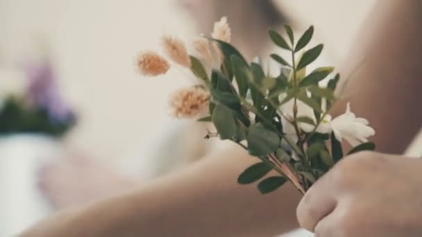 Gros plan : un fleuriste assemble une composition de fleurs. Fleuriste . — Video