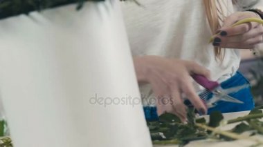 Konsantre ve tutkulu bir kız çiçekçi bir buket yapar