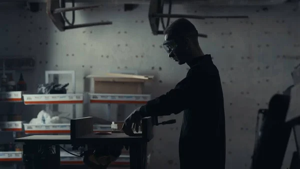 Marangoz bir elektrikli testere ile çalışır ve Ahşap ürünler işler.