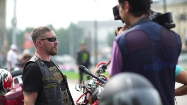 Novosibirsk 2016: TV-tripulação levar um entrevistado um adulto motociclista brutal — Vídeo de Stock