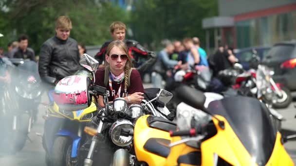 Russland, Nowosibirsk 2016: Frau mit Sonnenbrille sitzt auf Motorrad — Stockvideo