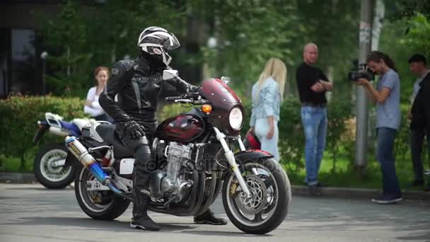 Novosibirsk 2016: motorista con casco y chaleco en motocicleta — Vídeos de Stock