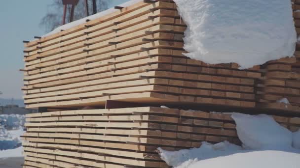 Desky pro stavbu stojící na ulici na pozadí bílého sněhu — Stock video