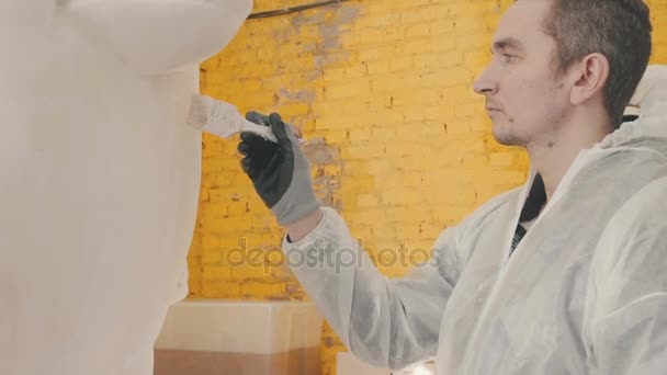 Man in the studio paints a figure of polystyrene foam — Stock Video