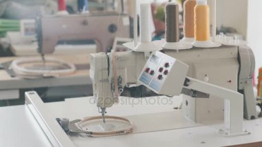 Sarı iplik bobinleri ile bir tekstil fabrikasında otomatik dikiş makinesi