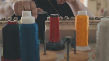 El seamstresses ile kırmızı ve sarı iplik bobinleri ayarlamak