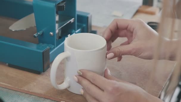 Imprime una foto en una taza blanca. Las manos del maestro pusieron la taza — Vídeos de Stock