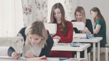 Bir grup genç kadını dikiş kursları: kesim ve dikiş.