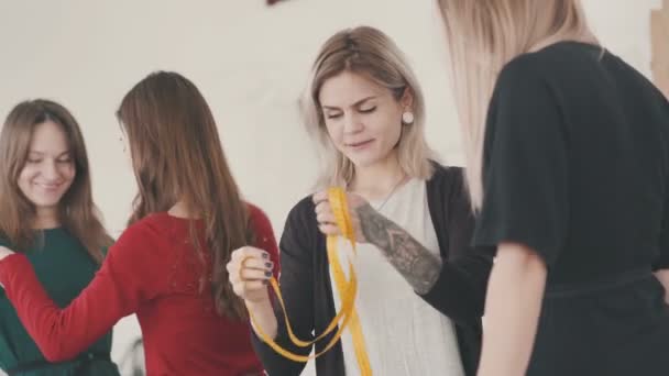 Sastre mujeres tomando medidas camisa usando cinta métrica . — Vídeos de Stock