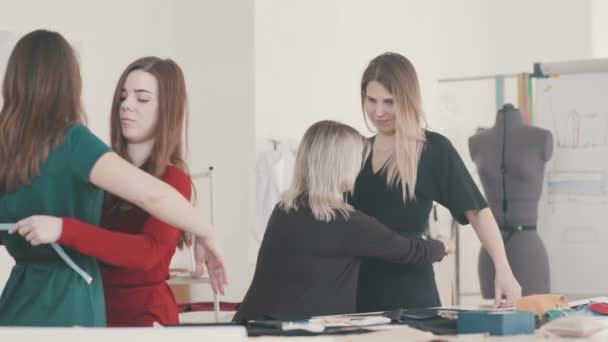 Joven costurera tomando medidas de cliente femenino . — Vídeos de Stock