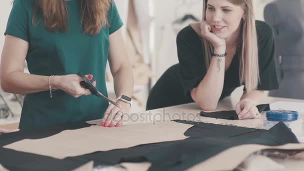 Seamstress mantém a mão tecido e cortes com uma tesoura . — Vídeo de Stock