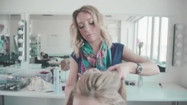 Kuaförlük kıvırcık saçlı bir kız styling yapar. Güzellik Salonu.