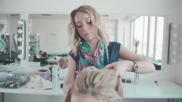 Friseur macht Styling zu einem Mädchen mit lockigem Haar. Schönheitssalon. — Stockvideo