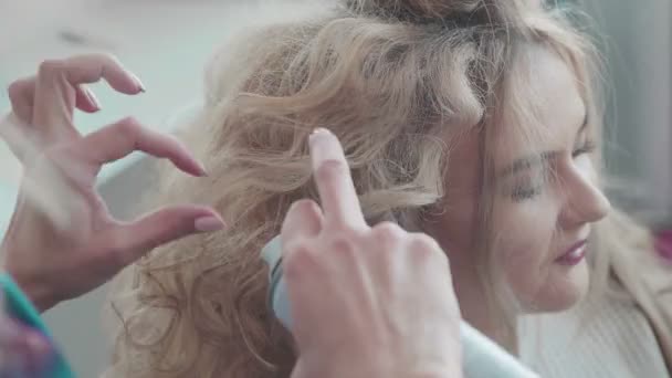 Una mujer en un salón. Peluquería en el trabajo. Cuidado del cabello y creación de cabello — Vídeos de Stock