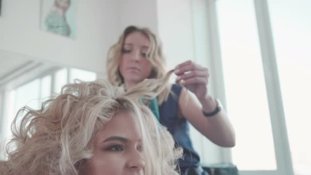 Sarışın saç maşası ile adlı kadın Kuaför yapma bukleler — Stok video