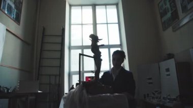 Bir genç kadın heykeltıraş antik bir adam figürü çamurdan yapılmış.